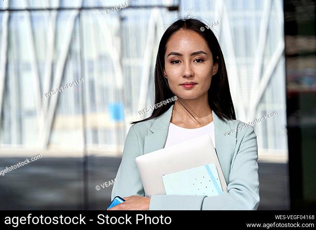 Beautiful female entrepreneur holding diary and wireless technologies