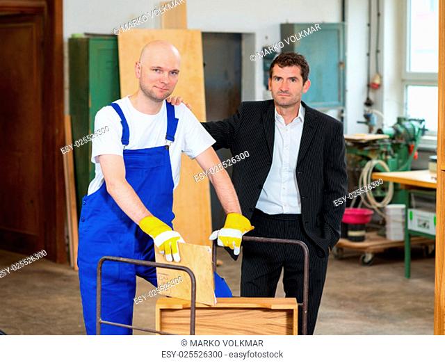 boss and worker together in a carpenter's workshop