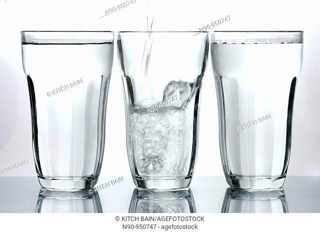 Glasses of drinking water backlit against a white background