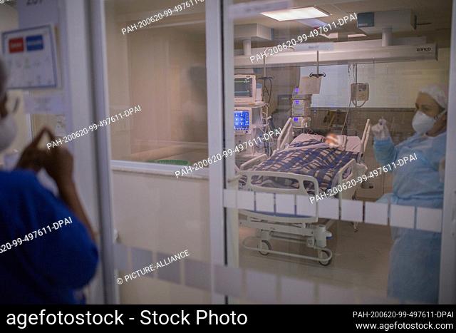 18 June 2020, Brazil, Sao Paulo: Employees of the intensive care unit of the Emilio Ribas Hospital talk with gestures. Brazil reported 54