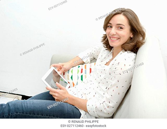 Beautiful young woman woman with a computer tablet in the sofa