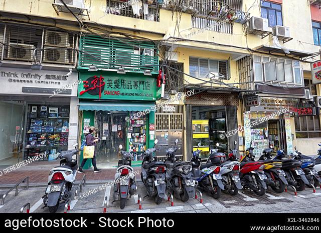 Motorbikes parked in front of old shops. Macau, China