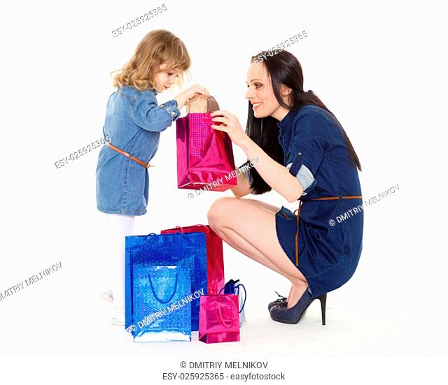 Young beautiful mother and sweet little daughter with shopping bags on a white background. Shopping family