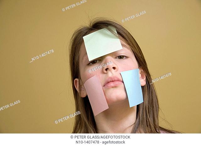 Preteen girl with post-it notes on her face