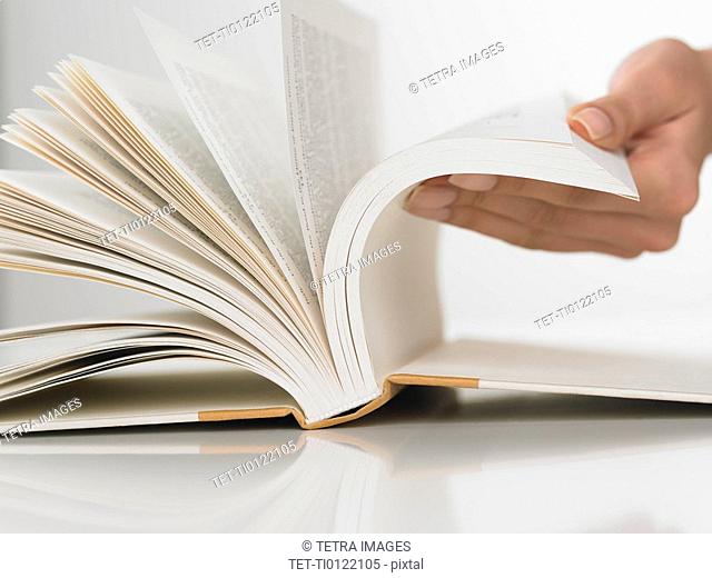 Close up of woman flipping pages in book