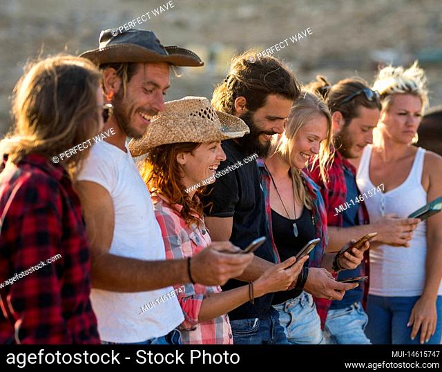 group of seven people using their phone together and enjoying - adults having fun and surfing in the net - social media and social network lifestyle and concept...