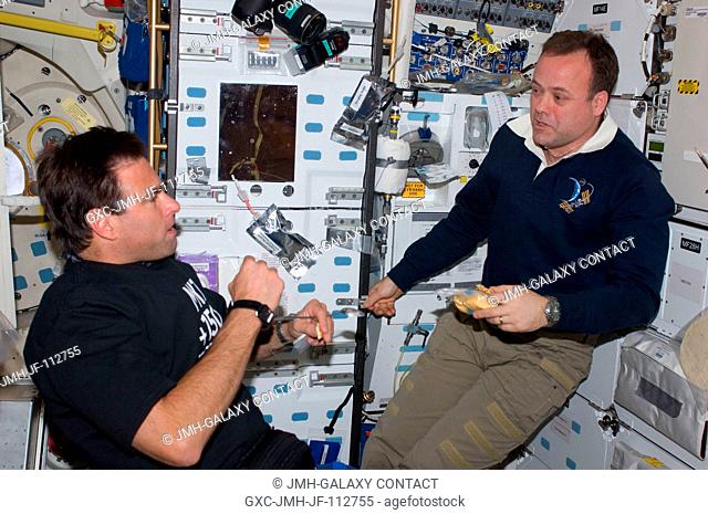 NASA astronauts Greg Chamitoff (left), STS-134 mission specialist; and Ron Garan, Expedition 28 flight engineer, discuss mission activities while enjoying a...