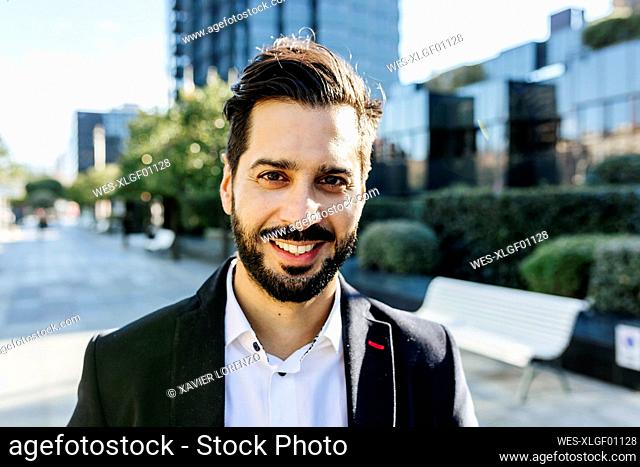 Businessman smiling while standing in city