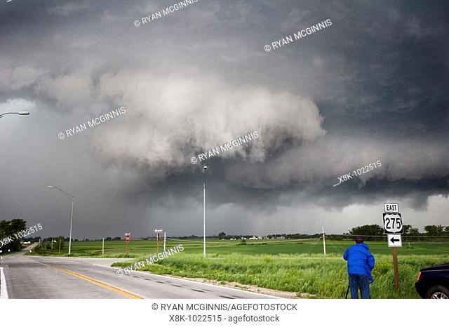 A wall cloud forms on a squall line near Valley, Nebraska, June 11, 2008, as a storm chaser films in the forground  The squall line produced multiple tornadoes...
