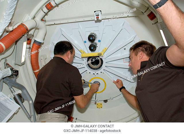 Astronauts Mark Polansky (left), STS-127 commander; and Christopher Cassidy, mission specialist, close the hatch on the middeck of Space Shuttle Endeavour prior...