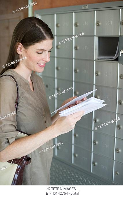 Woman checking post next to mailboxes