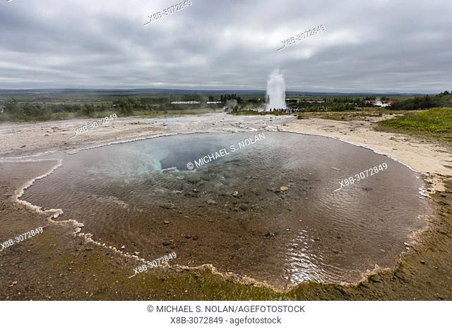 Tourists watch the eruption of the Strokkur geyser, Haukadalur valley, Hvítá River, Iceland