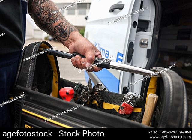28 June 2023, North Rhine-Westphalia, Cologne: A craftsman takes a bag with tools out of a vehicle. Tools have been stolen from tradesmen's vehicles in North...