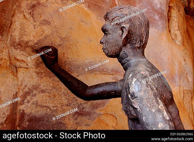 Prehistoric man attempting to make sketches on wall of his rock shelter at Bhimbetka, near Bhopal, Madhya Pradesh, India, Asia