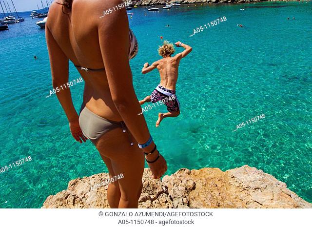 Young boy jumping into sea. Cala Salada beach. Santa Agnés de Corona. Ibiza. Balearic Islands. Spain