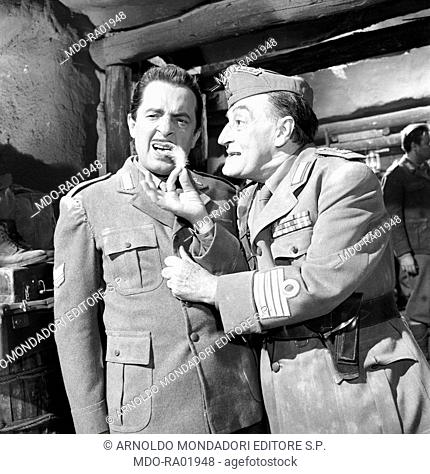 Italian actor Totò (Antonio De Curtis) showing a feather to Italian actor Nino Taranto in the film The Two Colonels. 1962
