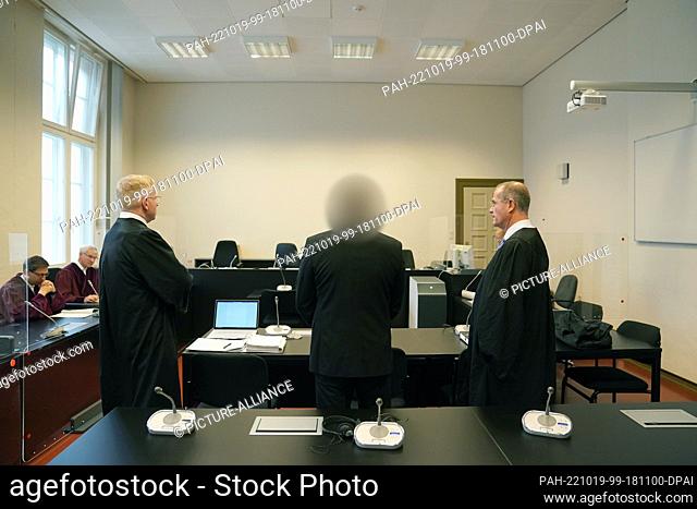 19 October 2022, Hamburg: The defendant (M) stands next to his lawyers Frank Brand (l) and Frank Thiemann in the courtroom of the Hanseatic Higher Regional...