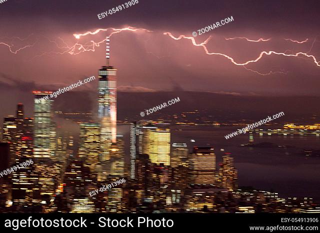 Artistic motion blured image of New York City skyline with lower Manhattan skyscrapers in lightning storm at night