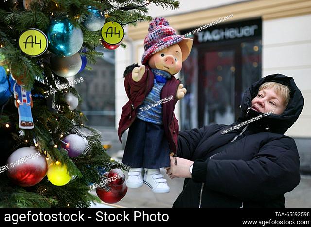 RUSSIA, MOSCOW - DECEMBER 19, 2023: A woman holds a puppet of Khryusha, a character in a children's television series, during the opening of an exhibition of...
