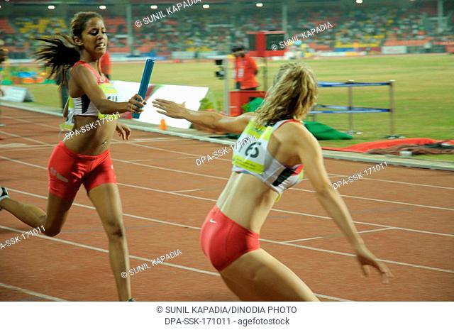 Foreigner athlete passing baton to another athlete ; Pune ; Maharashtra ; India 16-October-2008 NOMR