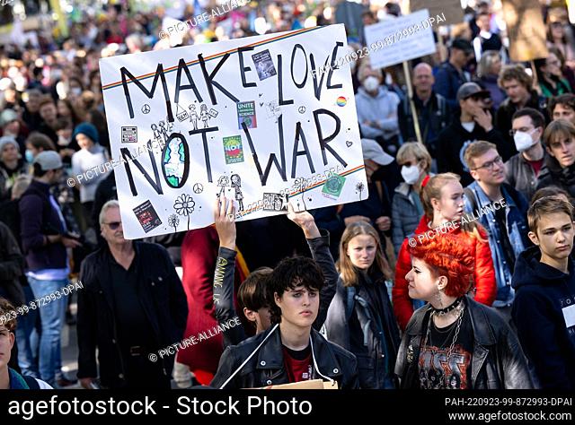 23 September 2022, Bavaria, Munich: Numerous people take part in a demonstration on the global climate strike, holding a placard with the inscription ""Make...