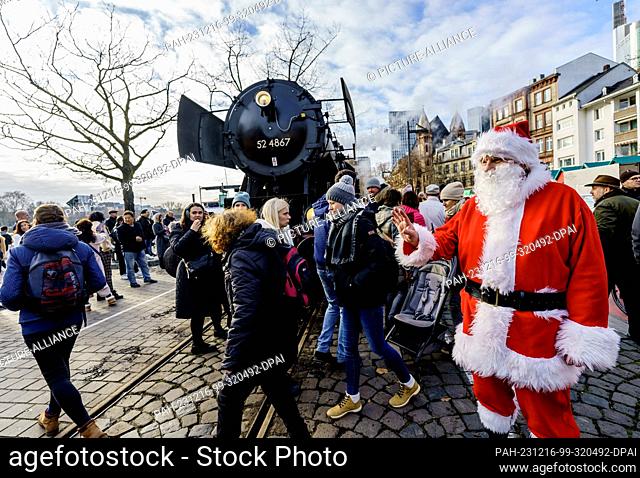 16 December 2023, Hesse, Frankfurt/Main: Santa Claus and the 52 steam locomotive of the ""Historische Eisenbahn Frankfurt e. V