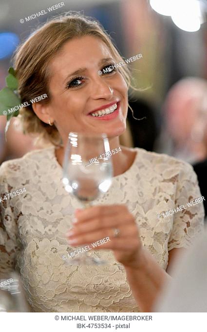 Bride with glass in her hand, cheers, Germany