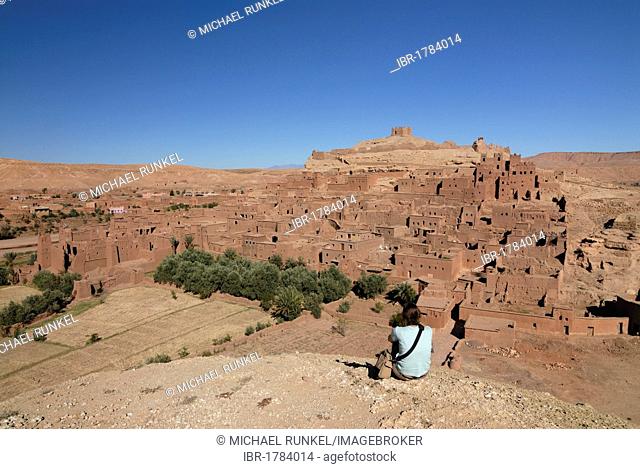 Young woman looking at the mountain village known as a film set, Ait Benhaddou, Morocco, Africa
