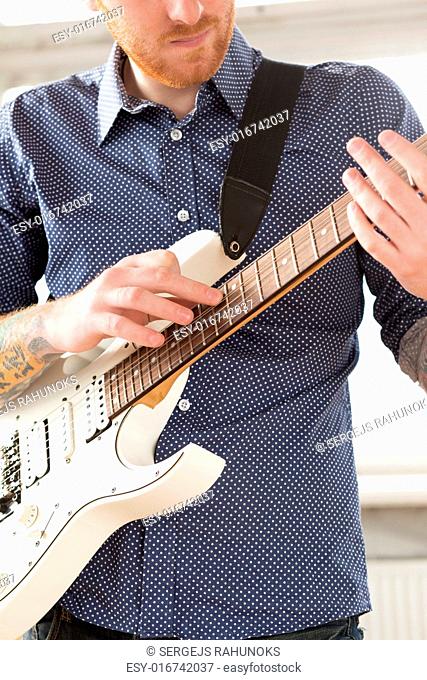 Handsome man playing on guitar