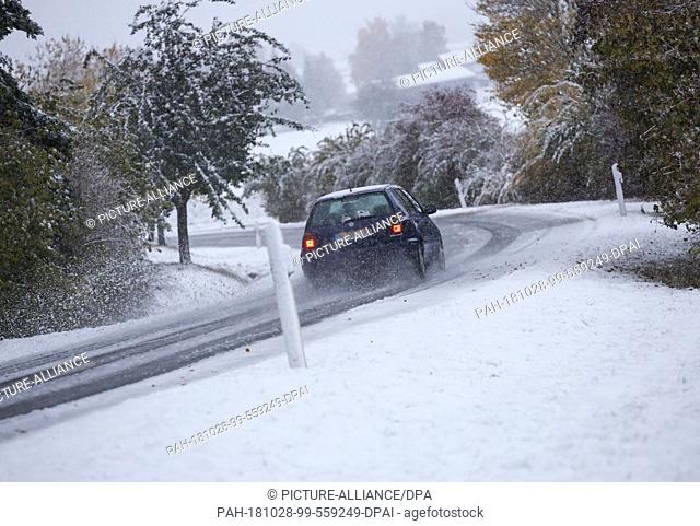 28 October 2018, Baden-Wuerttemberg, Dietelhofen: A car is on a snow-covered road. Photo: Thomas Warnack/dpa. - Dietelhofen/Baden-Wuerttemberg/Germany