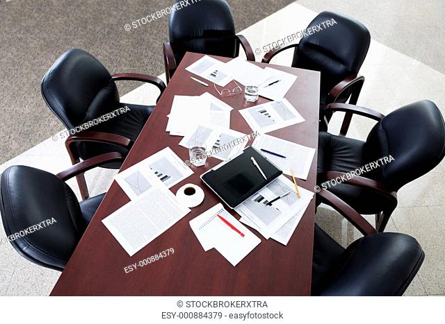 Image of large table and six black chairs in the boardroom