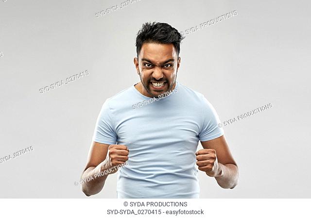 angry indian man screaming over grey background