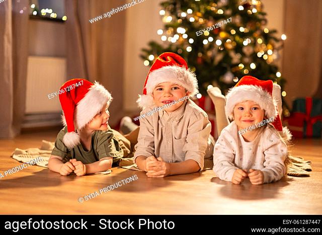 happy children in santa hats on christmas at home