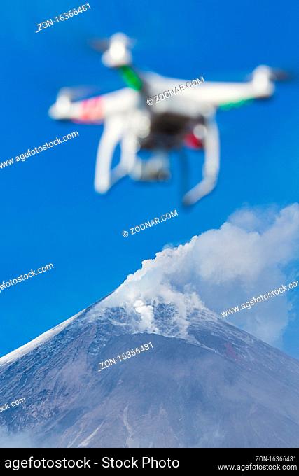 Flying UAV drone quadcopter aerial photography in sky on background volcano eruption, mountain peak erupting ashes, gas from active crater