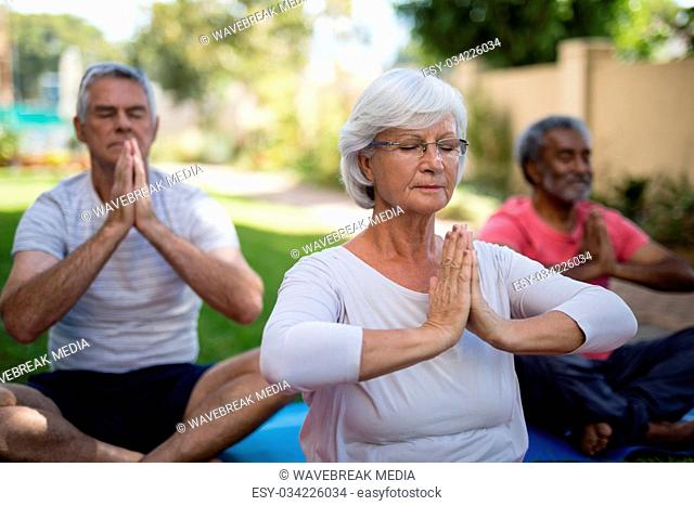 Senior people with closed eyes meditating in prayer position