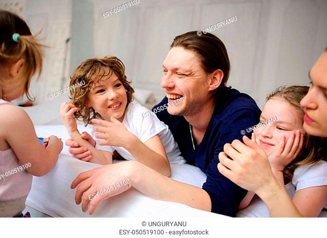 Morning in a big family. Father, mother and three children cheerfully begin new day