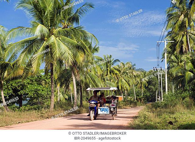 Tuk tuk motorcycle taxi driving on island road through palm trees, Golden Pearl Beach, Ko Jum or Koh Pu island, Krabi, Thailand, Southeast Asia