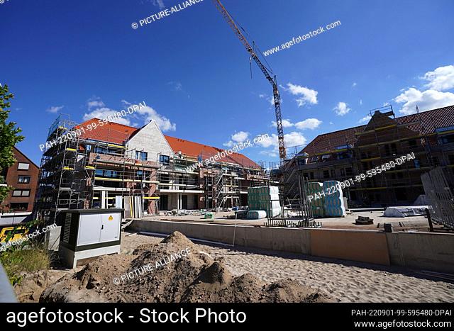 01 September 2022, Schleswig-Holstein, Rendsburg: Workers are seen at a construction site for residential buildings on the site of the former barracks in...