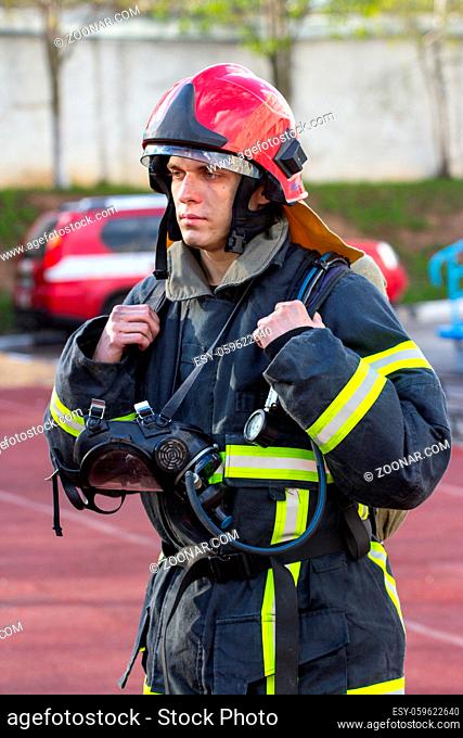 Portrait of heroic fireman with an axe outdoors