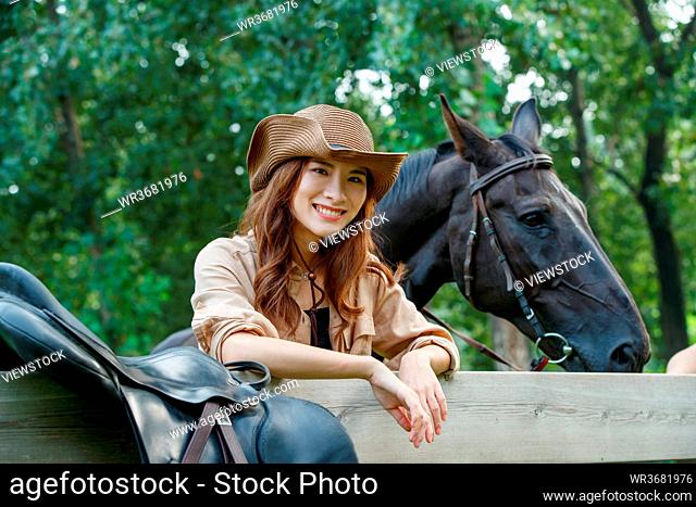 Outdoor happy fashionable young women and horses