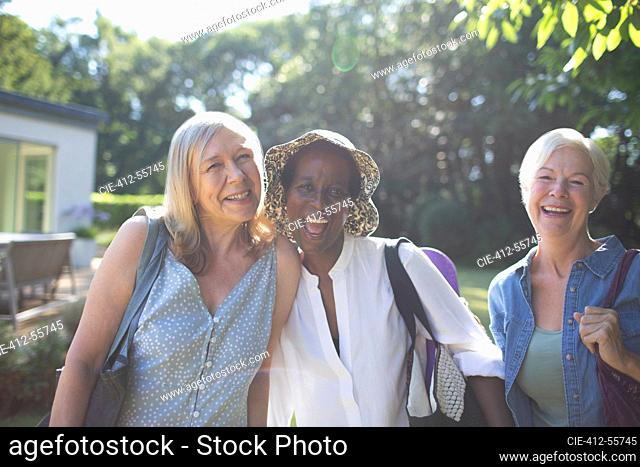 Portrait playful senior women friends in sunny summer garden