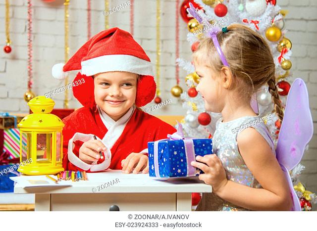 Santa Claus and fairy fun to look at each other's assistant preparing greeting cards and gifts
