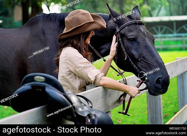Outdoor young woman touch steed