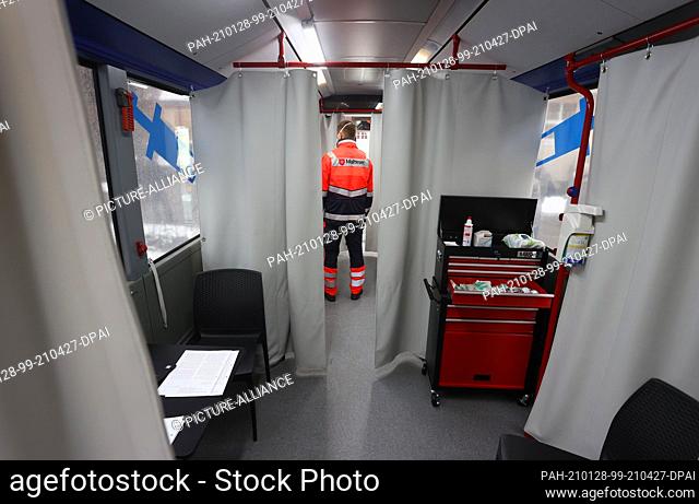 28 January 2021, Bavaria, Memmingen: A staff member of the relief organisation Malteser stands in a vaccination bus at the municipal vaccination centre