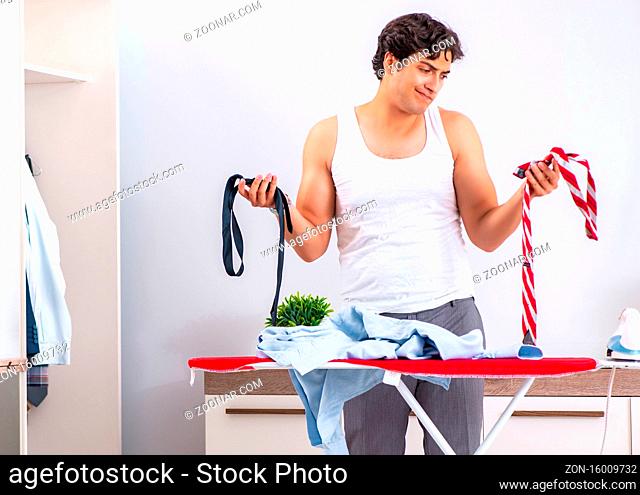 The young man ironing in the bedroom