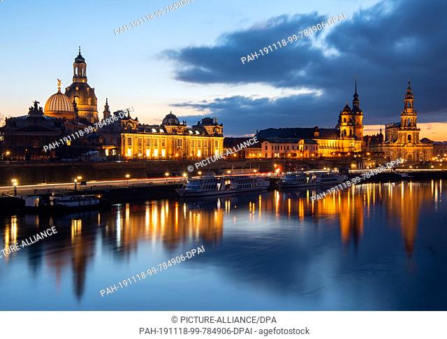 18 November 2019, Saxony, Dresden: The lights of the historic old town scenery with the Lipsius building (l-r), the dome with the angel ""Fama""