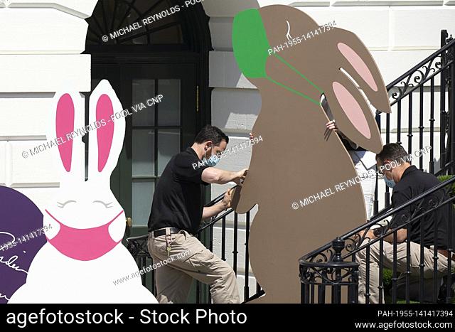 Decorations depicting Easter bunnies wearing face masks are seen at the South Portico steps of the White House before US President Joe Biden (not pictured)...