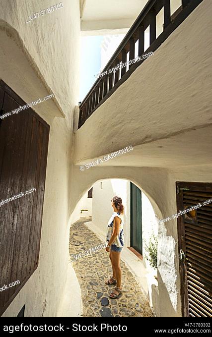 A tourist walks through the narrow streets of the old town of Binibeca, Menorca