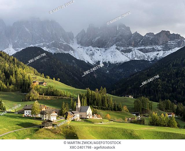 The church Sankt Magdalena in the Villnoess valley in the Dolomites during autumn.The peaks of the Geisler Mountain Range (Gruppo delle Odle)