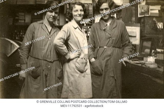 Three women in a small business - wearing overalls - sadly their exact profession is not easy to determine. The machine (back left) may be some form of...